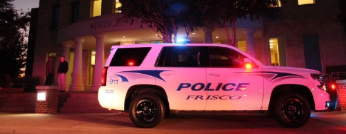A police vehicle flashes its lights in front of the Frisco Police Department headquarters.
