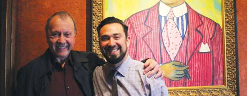 Fonda San Miguel co-owner Tom Gilliland (left) and General Manager Danny Herrera stand next to the first artwork purchased for the interior Mexican restaurant when it opened in 1975.