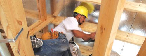 Hector Martinez, a subcrew foreman with Big Tex A/C, installs air-conditioning ducts in a house being built on Legend Trail in Leander.