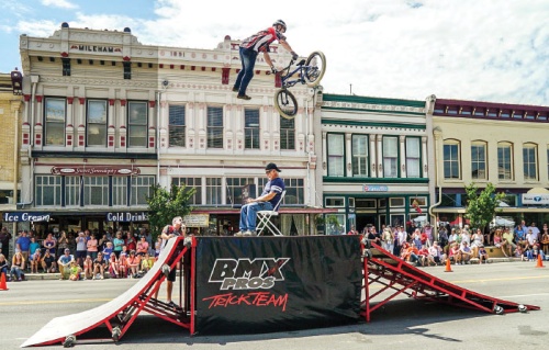 A member of the BMX Pros Trick Team jumps over Georgetown photographer Rudy Ximinez during the 2015 Red Poppy Festival.