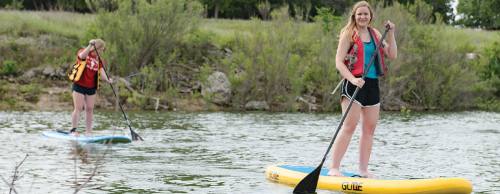 Morghan Embry (right) a co-owner of Georgetown Paddle Co., paddleboards with her friend Emily Bell on Lake Georgetown.