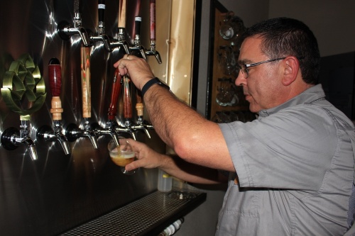 Deca Beer co-owner Cody Evans pours a glass of Lite Brite, one of the 18 beers brewed and sold at the brewery in Porter. (Wesley Gardner/Community Impact Newspaper)
