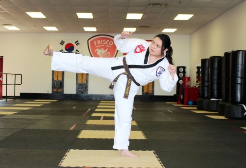 Marai Jimenez demonstrates a standing kick. She is preparing to take the national test in May to earn her fifth-degree black belt. (Karen Chaney/Community Impact Newspaper)