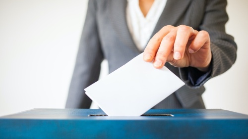 Person putting ballot into a ballot box