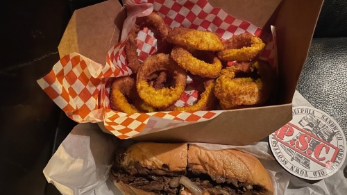 Philly cheesesteak, onion rings, coaster