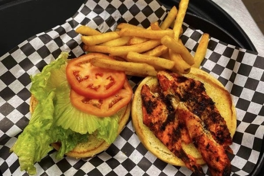 Grilled chicken, lettuce and tomato on a bun with french fries