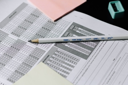 A white pencil rests on a standardized test form.