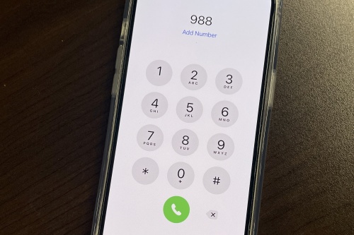 An image of the Phone app on an Iphone. The numbers "988" are typed on the screen.