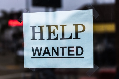 A sign that says "HELP WANTED" is taped to a window.