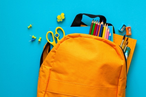 Stock photo of a backpack filled with pencils and other school supplies