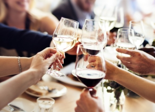 people cheers-ing with wine glasses at a table