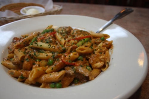 Reyes chipotle pasta is made with penne pasta, served with asparagus, red bell peppers, mushrooms, peas, cilantro and chicken in a spicy chipotle cream sauce. (Shawn Arrajj/Community Impact Newspaper)