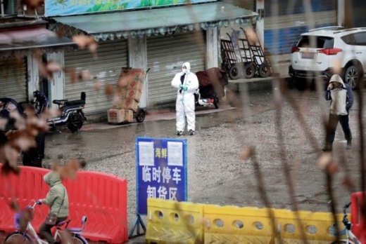 A worker in a protective suit stands near the closed seafood market in Wuhan, China. (Reuters/Darley Shen)