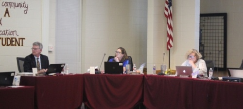 A photo of Ron Jones, Joanna Day, and Barbara Stroud at a board of trustees meeting.