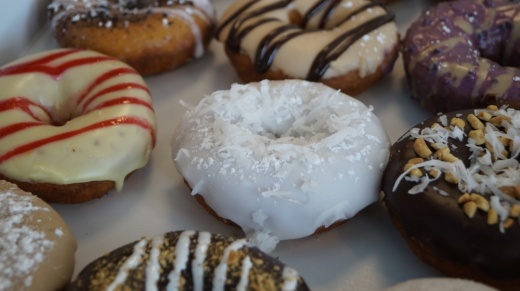 Classic toppings available at Duck Donuts include chocolate icing, blueberry icing, coconut, maple bacon, raspberry drizzle and more. (Kelsey Thompson/Community Impact Newspaper)