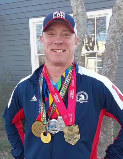 Leander's Ray Sterriker wears his five medals that are part of the marathon series. (Brian Perdue/Community Impact Newspaper)