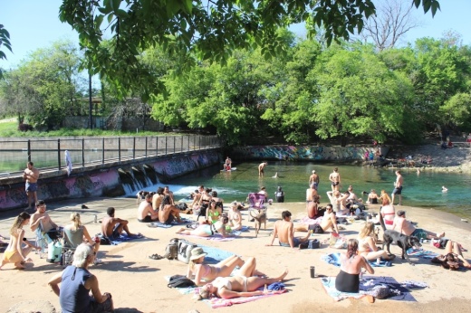 With heavy restrictions on public gatherings in place, sizable crowds gathered on the free side of Barton Springs pool March 24, only hours before Austin's stay-at-home order went into effect. (Christopher Neely/Community Impact Newspaper)