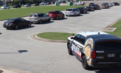 A Leander Police Department SUV is parked outside Bagdad Elementary School as vehicles line up during a Leander ISD student lunch giveaway March 25. (Brian Perdue/Community Impact Newspaper)