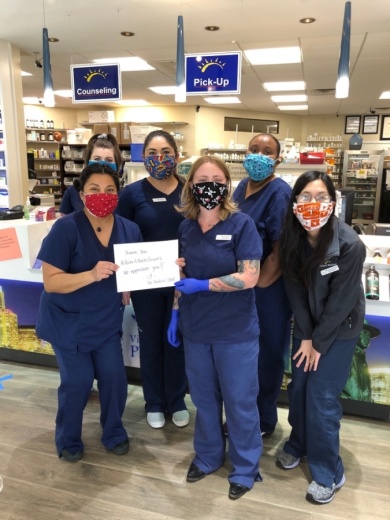 A photo of five medical workers wearing hand-sewn masks and holding a sign that reads "Thank you #MakeAMask sewers."