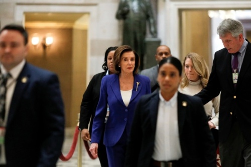 House Speaker Nancy Pelosi speaks to reporters while walking to the House Chamber floor, ahead of a vote on a coronavirus relief bill on Capitol Hill in Washington on March 27. (Courtesy Reuters/Tom Brenner)