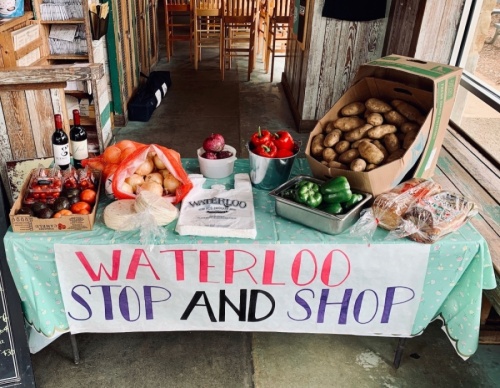 A photo of a pop-up grocery market with a sign that reads "Waterloo Stop and Shop"