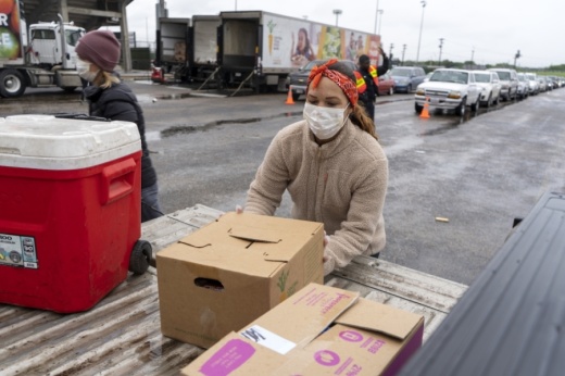 A volunteer unloads food from a truck during the Central Texas Food Bank's April 4 event to feed families in need at Nelson Field in Austin. (Courtesy Central Texas Food Bank)