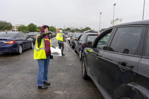 A Central Texas Food Bank volunteer directs traffic during a food drive at Nelson Field on April 4. (Courtesy Central Texas Food Bank)