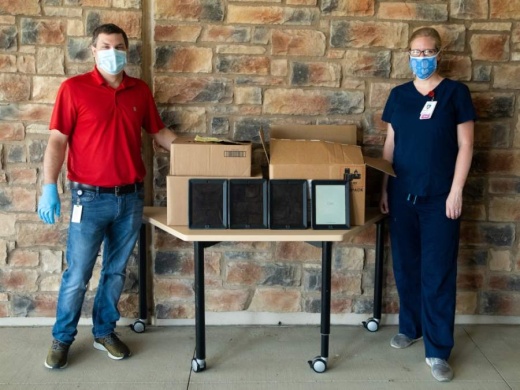 Matt Prause, LISD’s director of hardware/software support, and Stephanie Herbison, representing Dell Seton Medical Center, are pictured with the donated iPads on May 4. (Courtesy Leander ISD)