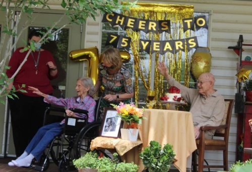 Denise and Carl Starnes, who celebrated their 75th wedding anniversary May 5, wave to their four great-grandchildren during a surprise, socially distant party at Brookdale Round Rock, an assisted-living facility where the couple reside. (Brian Perdue/Community Impact Newspaper)