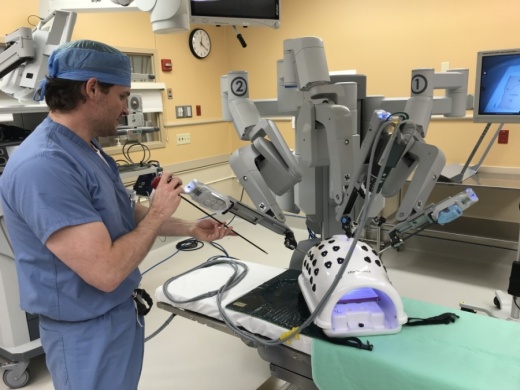 Dr. Wade Dunlap, a general surgeon at St. David’s Georgetown Hospital, adjusts some of the instruments on the robot. When operating the equipment during a procedure, he sits at a console and guides the instruments remotely. (Courtesy St. David's HealthCare)