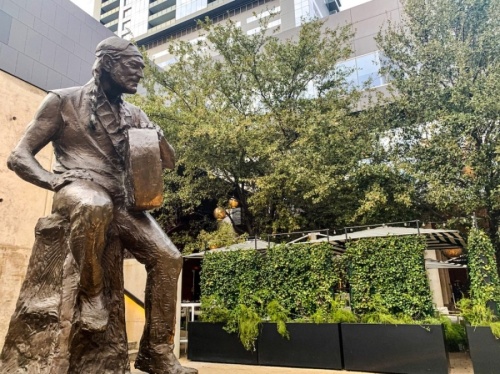 A statue of Willie Nelson sits across from Austin City Hall at the corner of Lavaca and Second streets. (Community Impact Newspaper Staff)