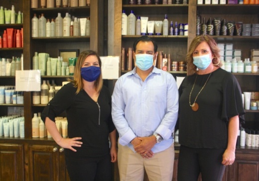 Amber Hall (left) is the area manager for the Salons at Stone Gate and The Factory Cypress. Her aunt and uncle Stephanie (right) and Gino Hernandez (middle) own both locations. (Danica Smithwick/Community Impact Newspaper)