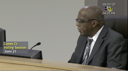 A screen image of Sam Biscoe at a meeting of the Travis County Commissioners Court