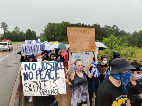 As rainfall let up, protesters circled back and forth across the Lake Woodlands Drive bridge. (Ben Thompson/Community Impact Newspaper)