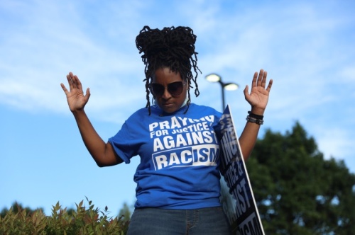Many of those present at the gathering of Collin County Churches wore shirts and held signs that said "praying for justice and against racism." More shirts with the same message were handed out to the crowd. (Liesbeth Powers/Community Impact Newspaper)