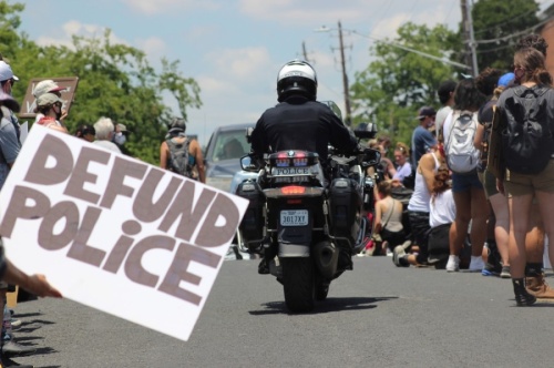 A police officer rides past a protester during the June 7 Justice for them All March. (Christopher Neely/Community Impact Newspaper)