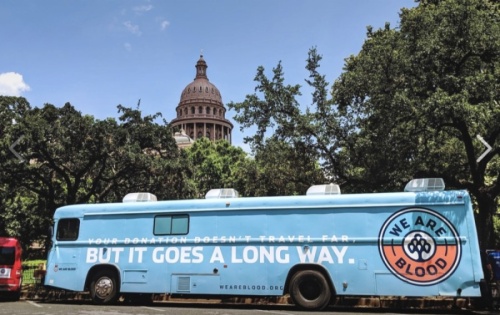 We Are Blood's mobile clinic is parked in front of the Texas Capitol Building.