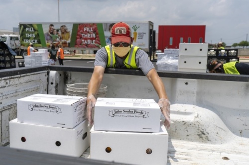 Volunteers help load food at an event hosted by the Central Texas Food Bank at Del Valle High School in April. (Courtesy Central Texas Food Bank) 