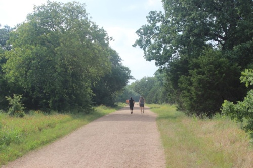 A photo of two women walking on a trail
