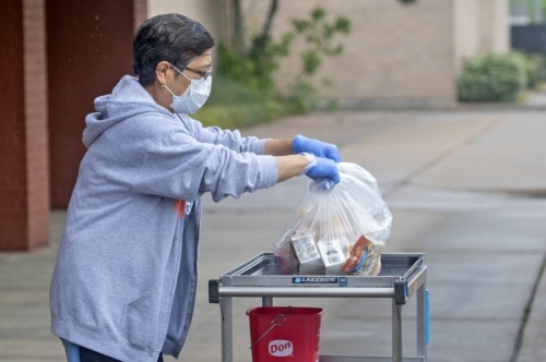 A Cy-Fair ISD employee distributes meals via curbside pickup for district students during the summer. (Courtesy Cy-Fair ISD)