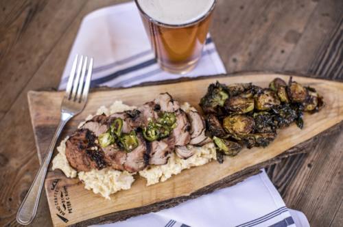 The Kentuckyaki Grilled Pork Tenderloin ($28) is served on a bed of creamed corn rice grits, with a side of fried green Brussels sprouts, green apples and jalapeno honey. 