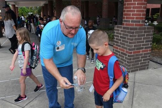 A Cy-Fair ISD volunteer assists a student in finding the right school bus during the Bus Buddies program in 2019. (Courtesy Cy-Fair ISD)