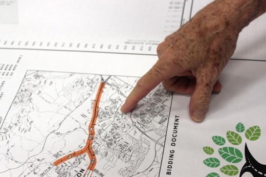 A resident points to a Oak Hill Parkway blueprint at a public open house in 2018. (Taylor Jackson Buchanan/Community Impact Newspaper)