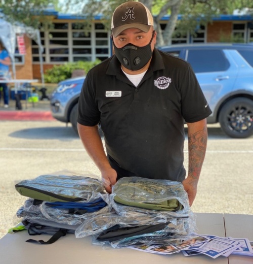 Miguel Ramirez, manager of the Georgetown Willie's Grill & Icehouse, packs backpacks full of school supplies that were given out to about 600 cars Aug. 11 at the Fill the Bus event sponsored by the Georgetown Area Junior Forum. (Courtesy Georgetown Area Junior Forum)