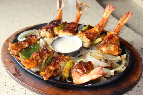 The Shrimp Brochette ($18.84) features eight bacon-wrapped jumbo shrimp stuffed with peppers, Monterey Jack cheese and grilled vegetables. (Adriana Rezal/Community Impact Newspaper)