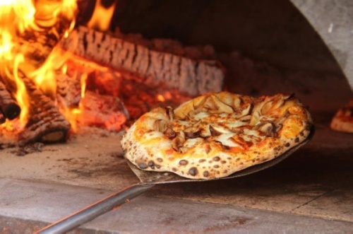 The neighborhood pizzeria uses wood-fired ovens to make its pizza. (Courtesy Delucca Gaucho Pizza & Wine)
