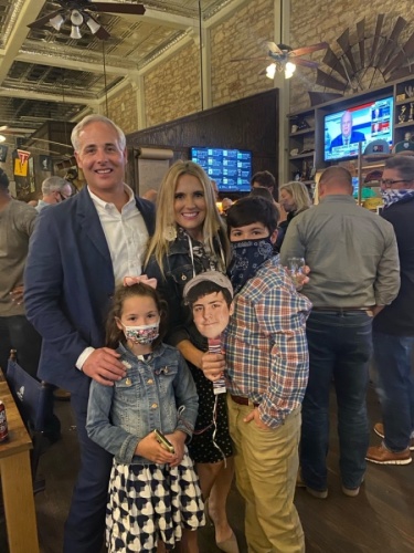 Josh Schroeder is seen with his family Nov. 3 at Mesquite Creek Outfitters, where they watched the election results come in. Schroeder's oldest son was in quarantine, so the family brought a picture of him so he could be included in photos from the occasion. (Courtesy Josh Schroeder)