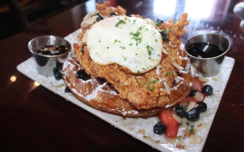 Chicken and waffles ($14.50): Cajun fried chicken breast brined in Cajun spices and cane syrup served over a Belgian waffle with shaved almonds, fresh berries and local honey.
