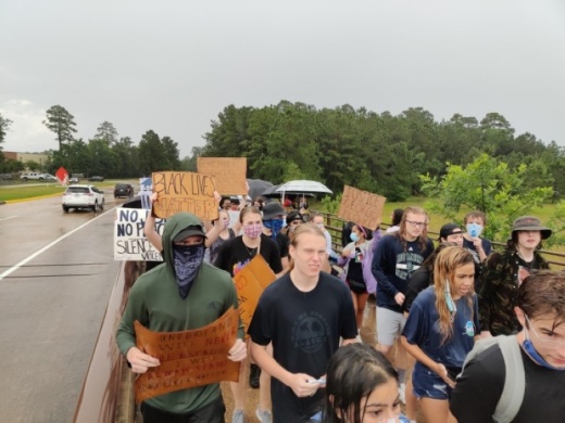 Several hundred protesters gathered on the Lake Woodlands Drive Bridge in the rain June 3 to protest the death of George Floyd in police custody May 25. (Ben Thompson/Community Impact Newspaper)