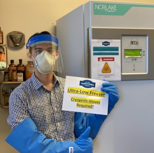 Photo: pharmacist in PPE standing in front of ultra-low freezer